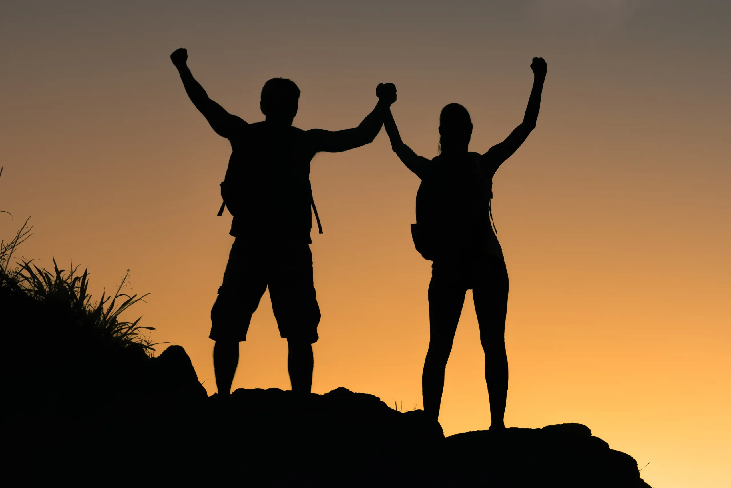B-Lean-IV-Therapy-Clinic A couple completing a mountain climb hold their arms up to the sunset. Get IV therapy for weight loss from Frank Lanzisera, D.C. in Tampa Bay Metro.