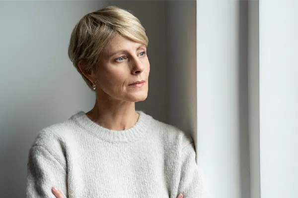 Chronic-Fatigue-Therapy A blond, middle-aged woman looks out the window with a tired expression. Get chronic fatigue treatment from Frank Lanzisera, D.C. in Tampa Bay Metro.