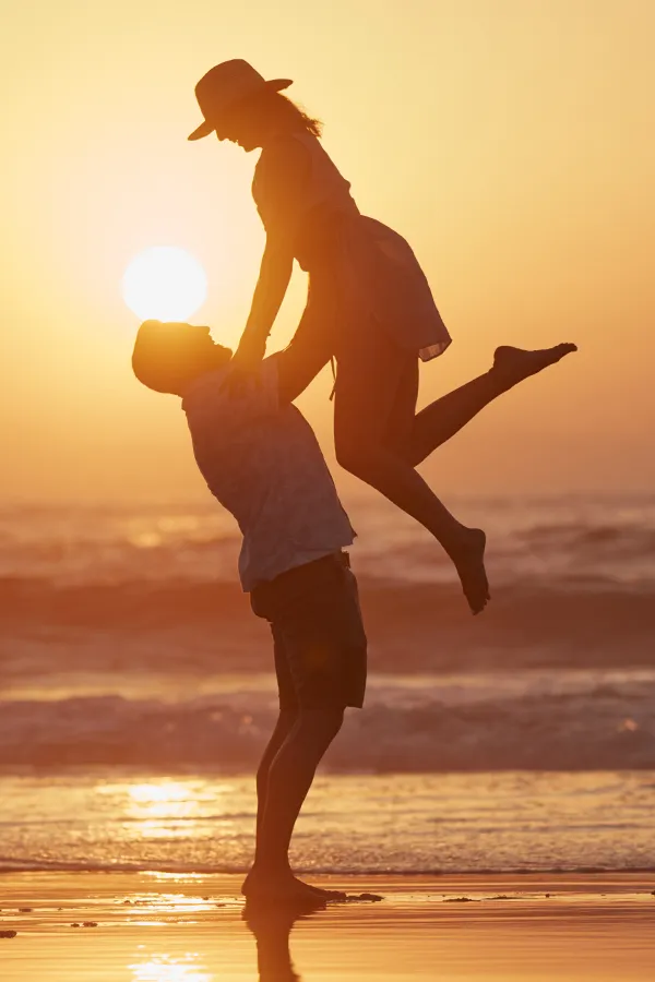 Chronic-Inflammation-Treatment A man lifts a woman on the beach. Get treatment for chronic inflammation from Frank Lanzisera, D.C. in Tampa Bay Metro.