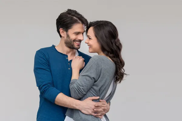Erectile-Dysfunction-Doctor A man in a blue shirt embracing a woman in a gray shirt smiles due to his successful erectile dysfunction care from Frank Lanzisera, D.C. in Tampa Bay Metro.