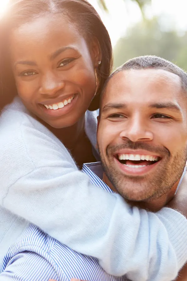 Erectile-Dysfunction-Treatment A woman riding on a man's back, both smiling due to help with erectile dysfunction from Frank Lanzisera, D.C. in Tampa Bay Metro.