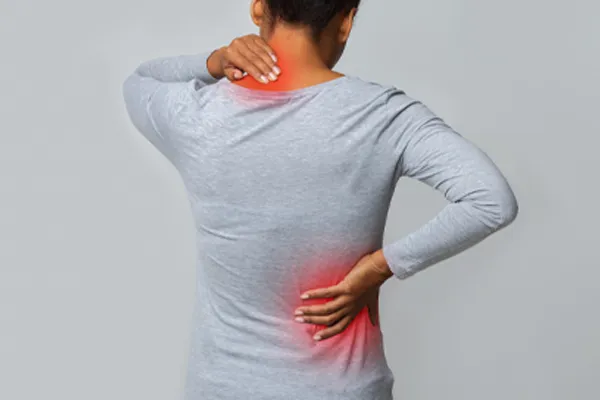 Fibromyalgia-Clinic An image from behind of a woman suffering from Fibromyalgia holding her hands on her neck and lower back. Get fibromyalgia care from Frank Lanzisera, D.C. in Tampa Bay Metro.