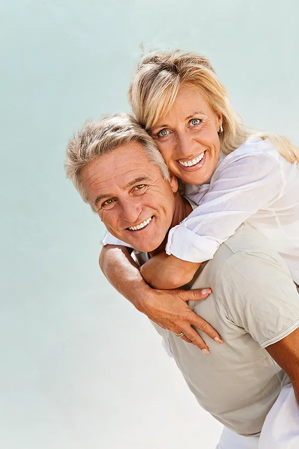 Food-Allergies-Treatment-1 A happy mature couple having fun - the husband is carrying his wife on his back. Get treatment for food allergies from Frank Lanzisera, D.C. in Tampa Bay Metro.