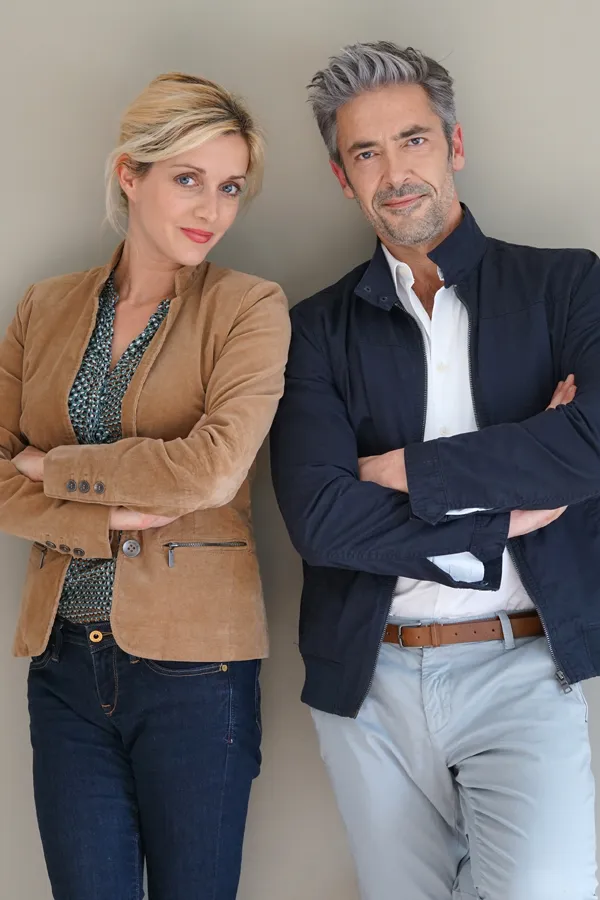 Hyperthyroidism-Treatment A middle-aged couple stand against a wall smiling with folded arms. Get hyperthyroidism treatment from Frank Lanzisera, D.C. in Tampa Bay Metro.
