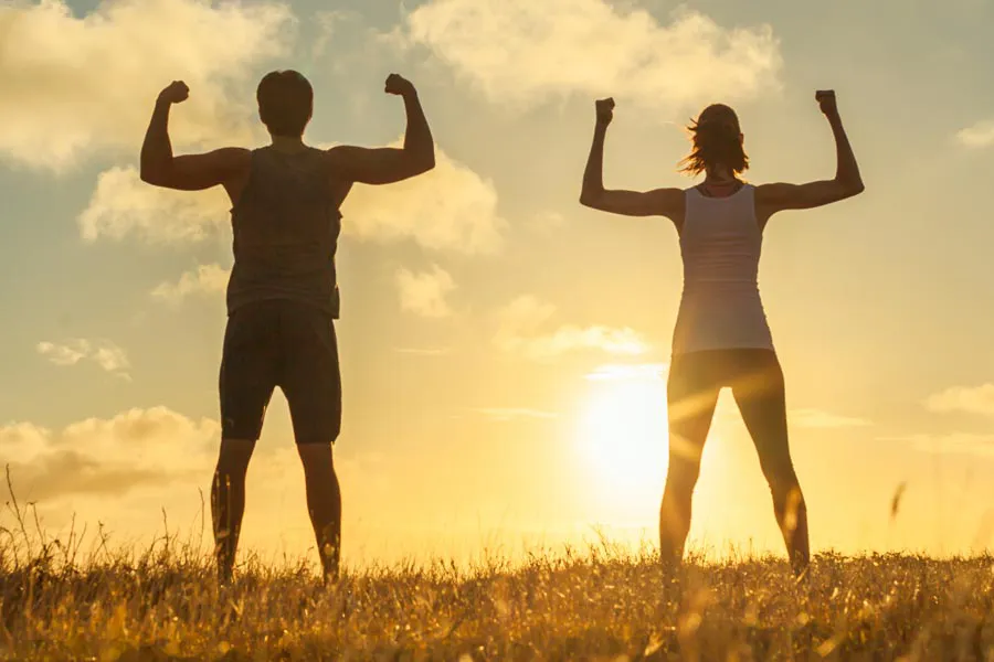 Immune-Boost-Injections-Clinic A couple flex their raised arms in the sunset. Schedule Tri-Immune Boost Injection treatments from Frank Lanzisera, D.C. in Tampa Bay Metro.