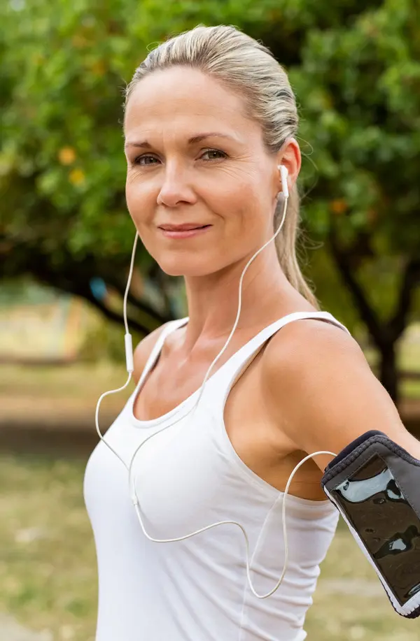 Insulin-Resistance-Treaatment A fit middle aged woman wearing earphones and a tank top smiles after a run. Get insulin resistance treatment from Frank Lanzisera, D.C. in Tampa Bay Metro.