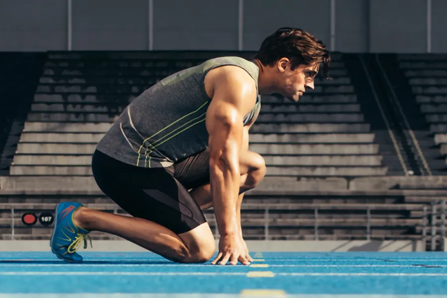 Lean-Muscle-and-Recovery-Clinic A white man kneels at the starting line on a track, determined to do his best. Get treatment for lean muscle loss and recovery from Frank Lanzisera, D.C. in Tampa Bay Metro.