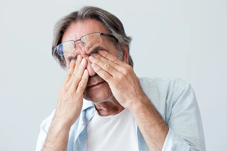 Migraine-Clinic Get migraine relief with Frank Lanzisera, D.C.'s functional medicine for migraines treatment in Tampa Bay Metro, represented by an older man rubbing his eyes due to head pain.