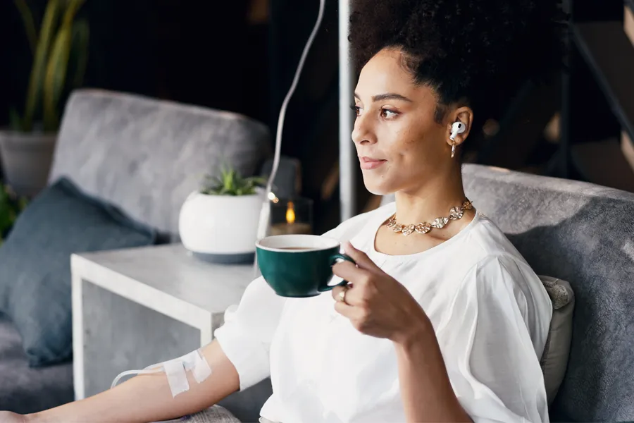 Mineral-IV-Drip-Clinic A woman with a cup of tea getting IV therapy. Schedule Brainstorm IV therapy from Frank Lanzisera, D.C. in Tampa Bay Metro.