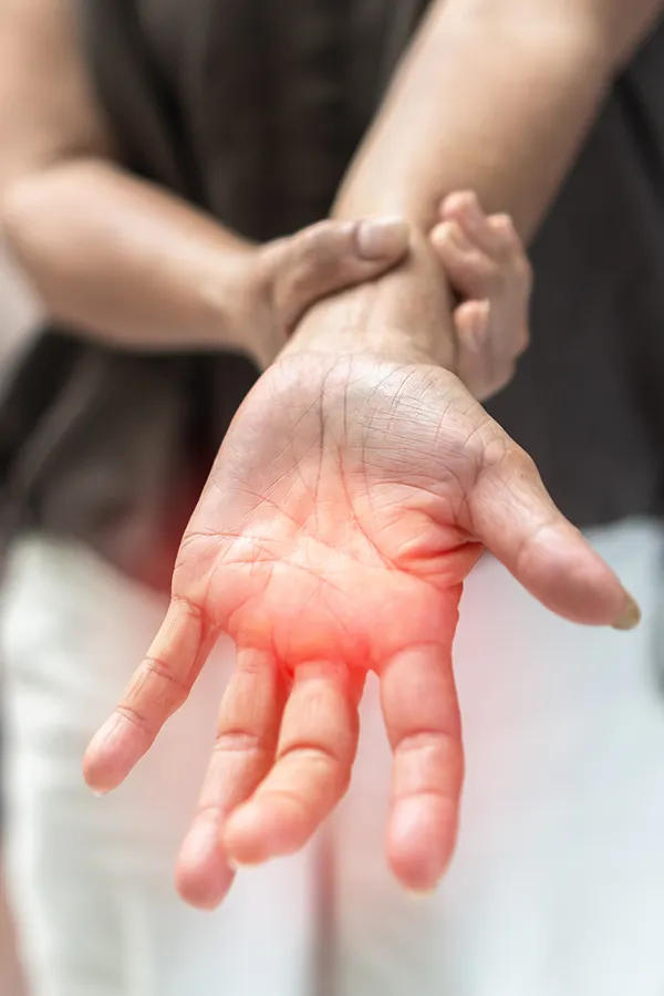 Neuropathy-and-Nerve-Pain-Treatment A woman holds her wrist with nerve pain. Get Neuropathy and Nerve Pain Treatment from Frank Lanzisera, D.C. in Tampa Bay Metro.