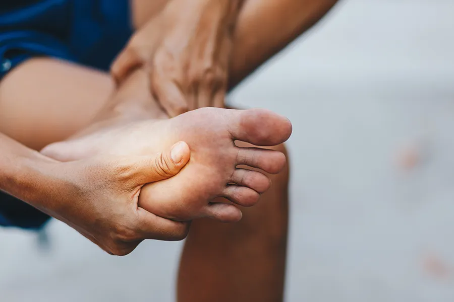Peripheral-Neuropathy-Clinic A man holds is foot which shows an inflamed area. Schedule treatment for peripheral neuropathy from Frank Lanzisera, D.C. in Tampa Bay Metro.