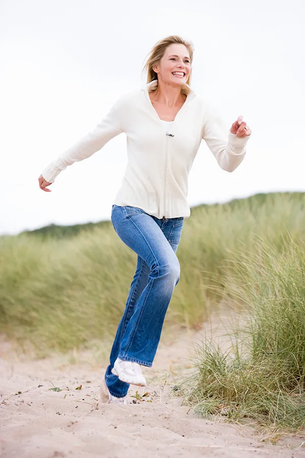 Peripheral-Neuropathy-Treatment A middle-aged woman runs through a meadow. Get treatment for peripheral neuropathy from Frank Lanzisera, D.C. in Tampa Bay Metro.