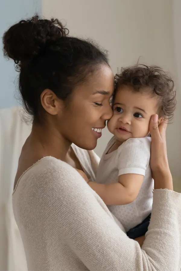 Postpartum-Hormone-Imbalance-Treatment A black woman happily touches her forehead to her infant's head. Get treatment for postpartum hormone imbalance from Frank Lanzisera, D.C. in Tampa Bay Metro.