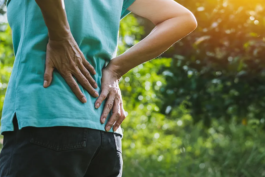 Regenerative-Medicine-for-Back-Pain-Clinic A woman holds her lower back in pain. Schedule Regenerative Medicine for Back Pain from Frank Lanzisera, D.C. in Tampa Bay Metro.
