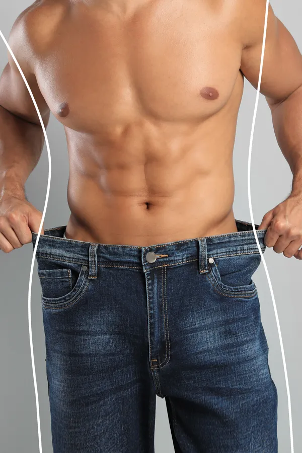 Semaglutide-Weight-Loss-Treatment A strong shirtless man in jeans holds the waistlines of his too-big jeans to show the success of semaglutide weight loss from Frank Lanzisera, D.C. in Tampa Bay Metro.