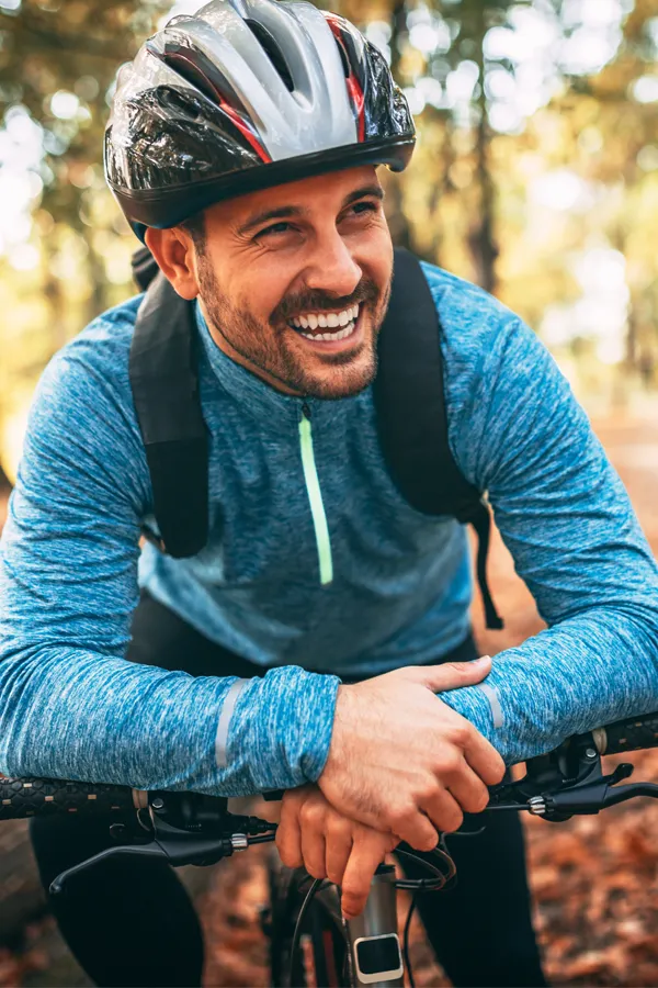 Testosterone-Low-T-Solutions-Treatment A middle-aged man on a trail in cycling clothes is smiling and leaning on his bike's handlebars. Get testosterone for Low T from Frank Lanzisera, D.C. in Tampa Bay Metro.