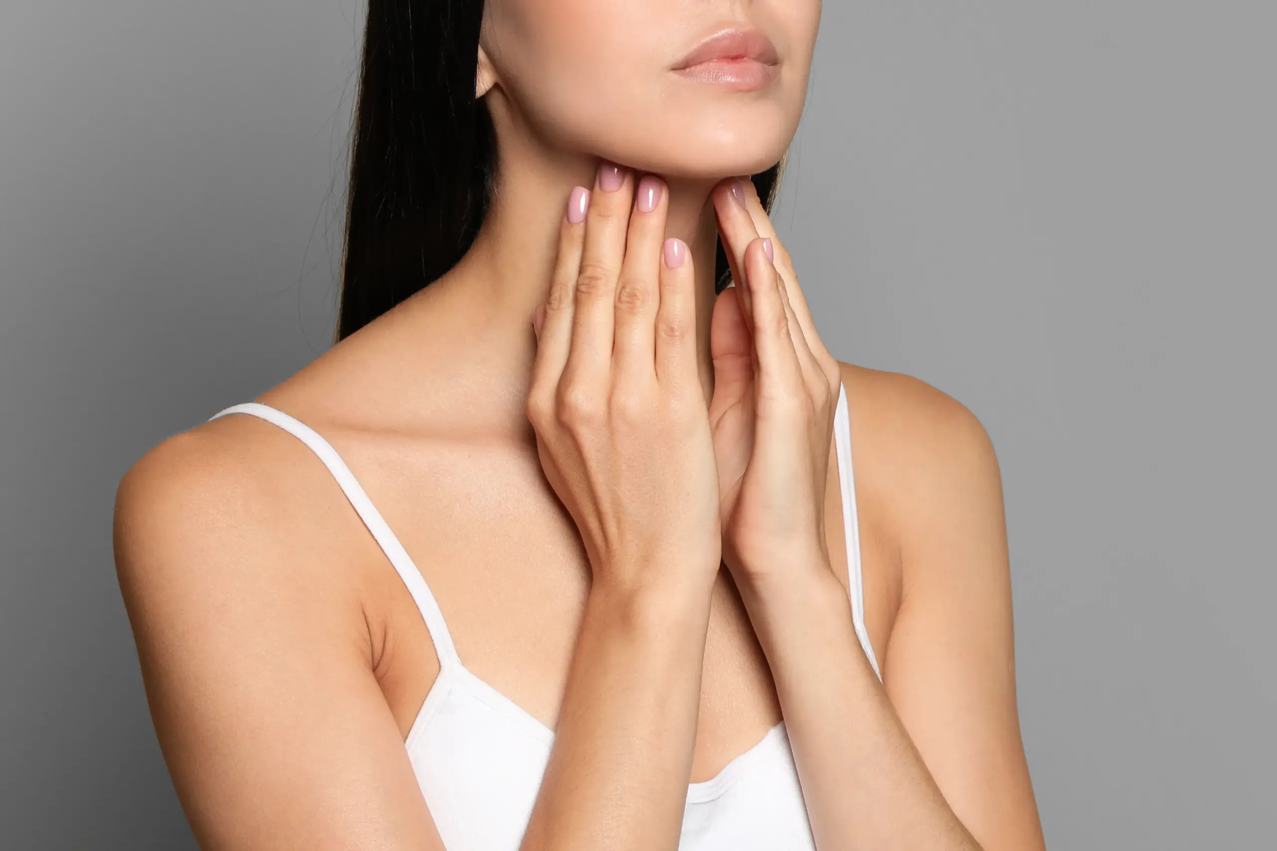 Thyroid-Doctor A woman in a white tank top touches her neck looking for signs of thyroid disorder. Get help for thyroid disorders from Frank Lanzisera, D.C. in Tampa Bay Metro.