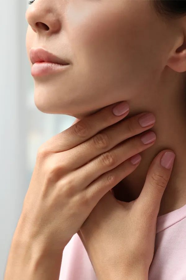 Thyroid-Symptoms-Treatment A woman holds her throat in pain. Get treatment for thyroid symptoms from Frank Lanzisera, D.C. in Tampa Bay Metro.